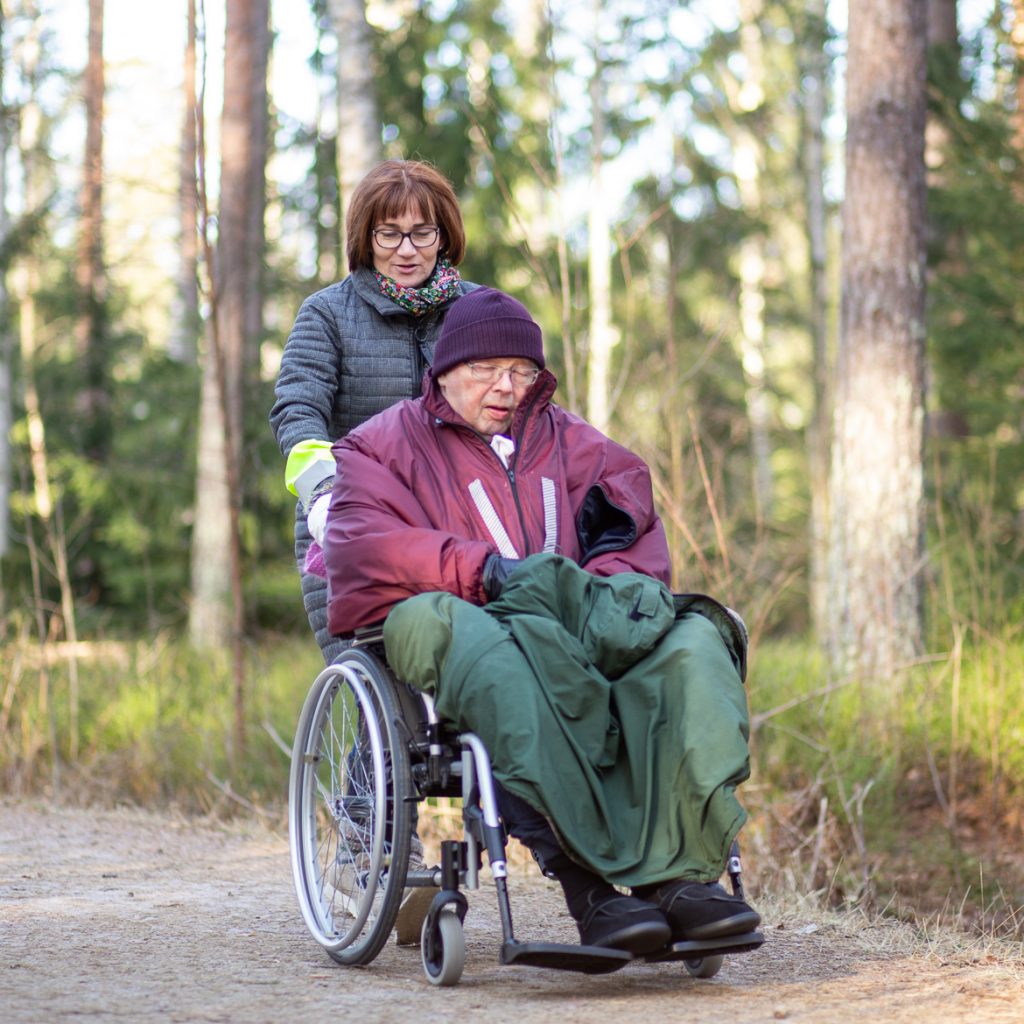 Valokuva yrityksestä Dementiakoti Villa Tapiola: hoitaja ja asukas lähimetsän lenkkipolulla