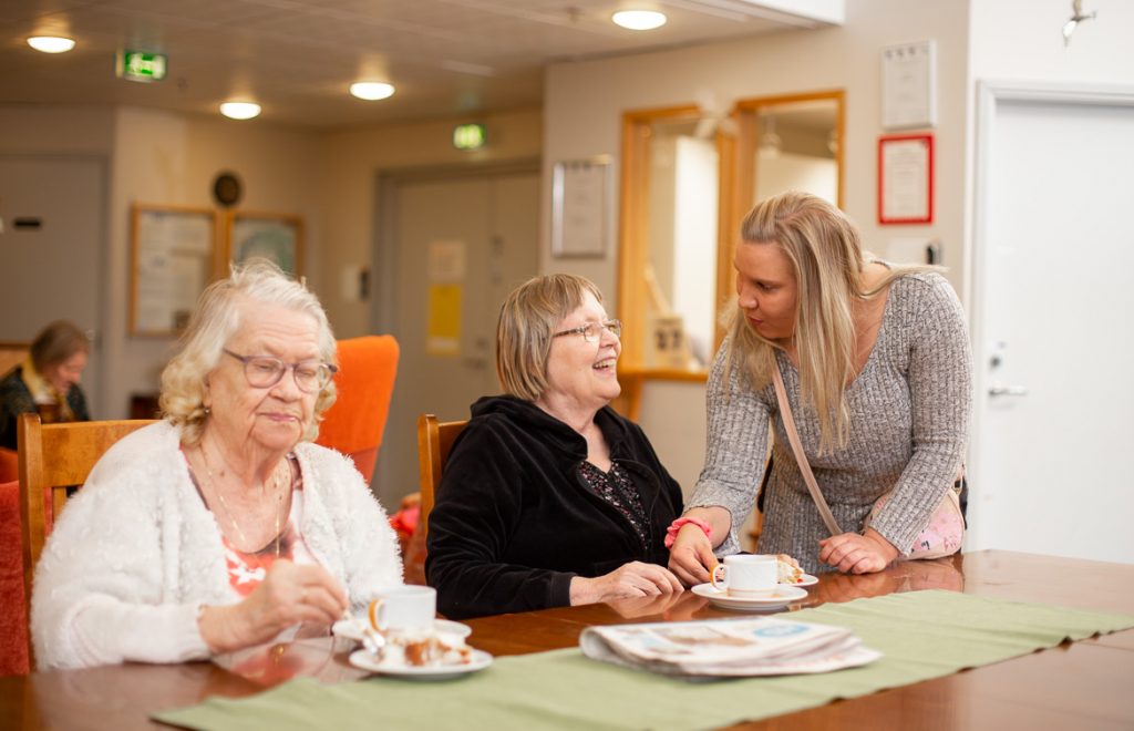 Valokuva yrityksestä Dementiakoti Villa Tapiola: hoitaja ja asukas keskustelevat iltapäiväkahveilla